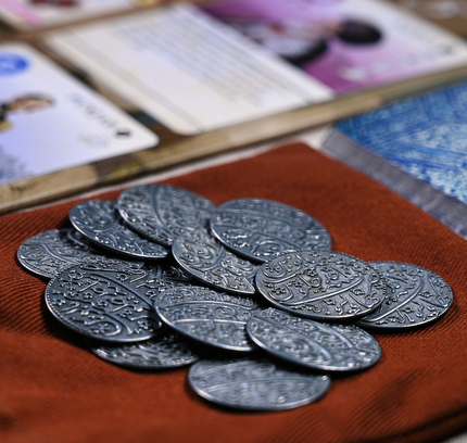 A close-up of the metal coins add-on for Pax Pamir.